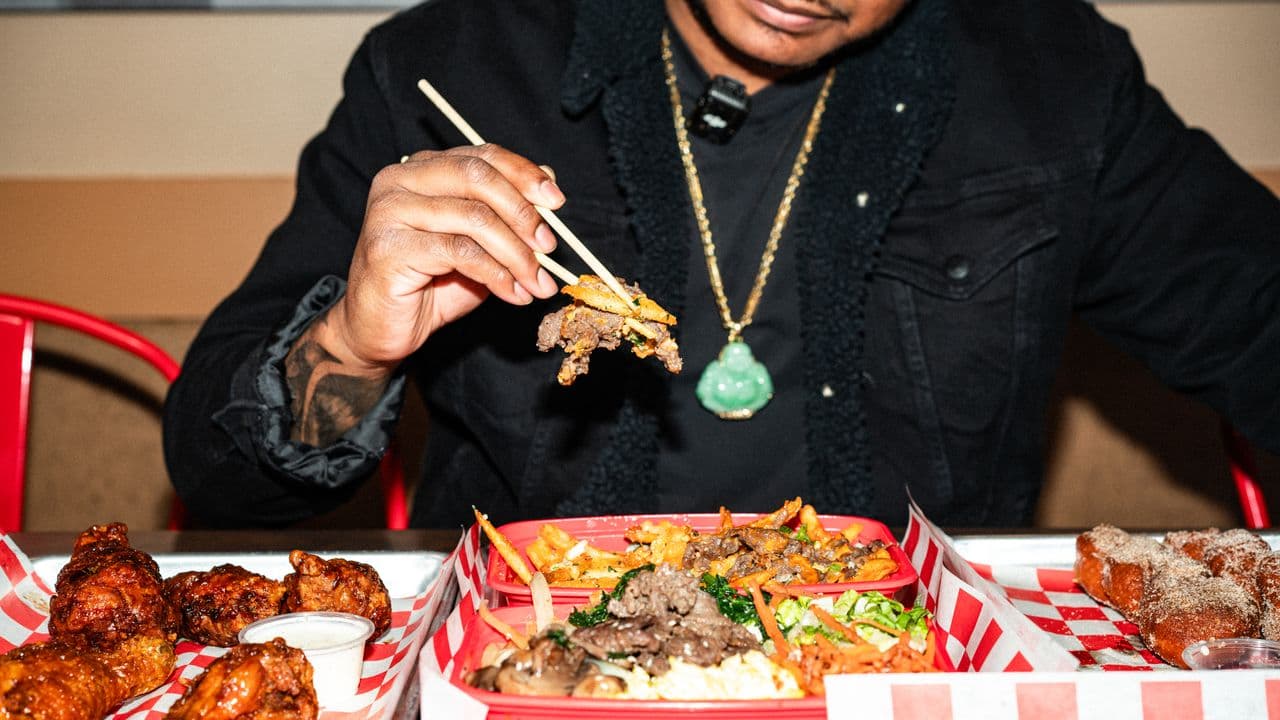 A guest eating a skewered dish at a restaurant table.