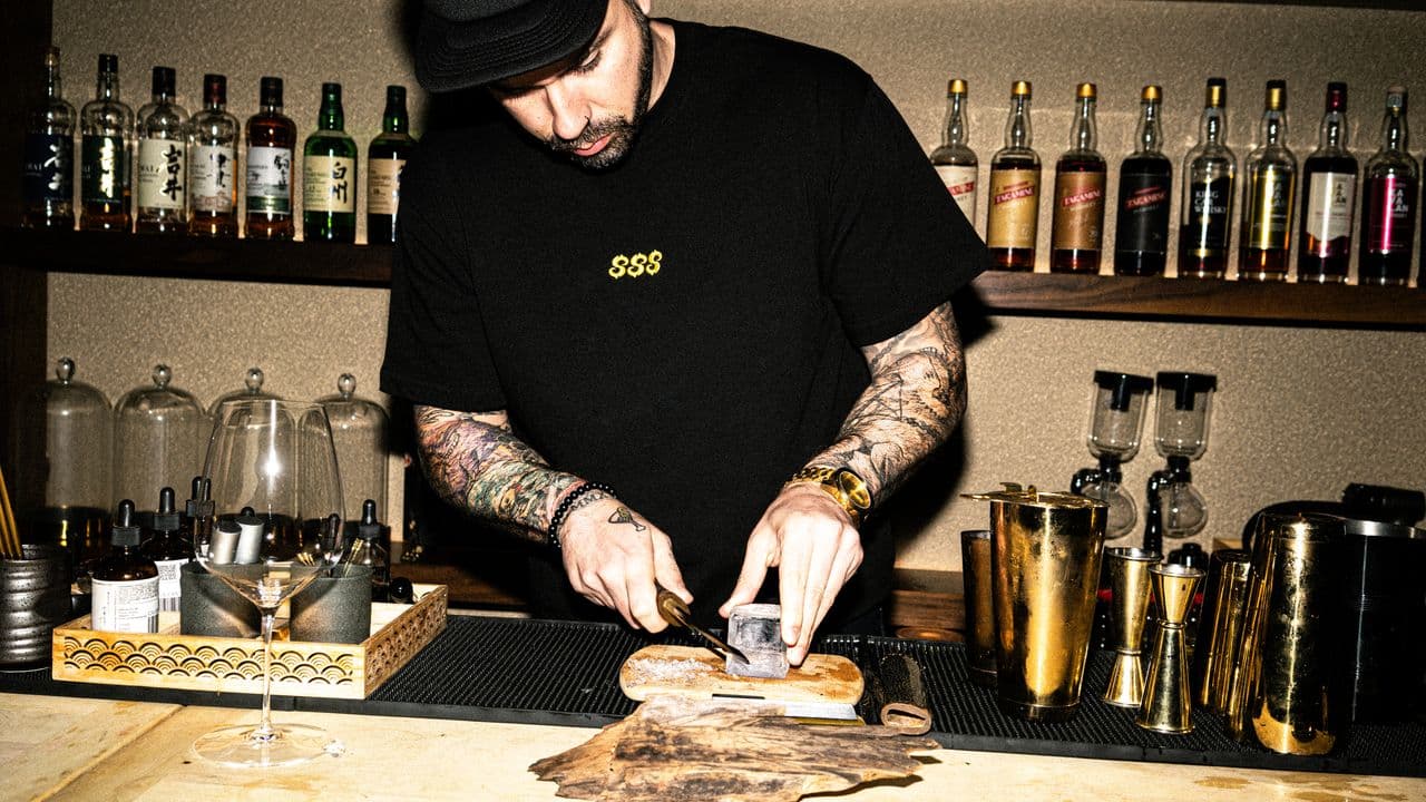 A bartender crafting a cocktail — finished content, not a stock shot.