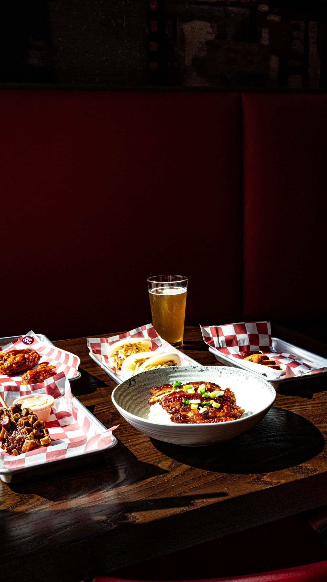 A restaurant food tray with wings, sliders, and a rice bowl.