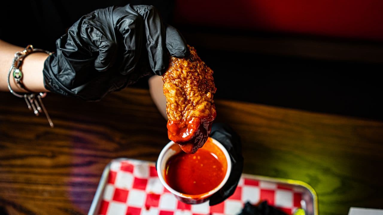A chicken wing dipped in sauce.