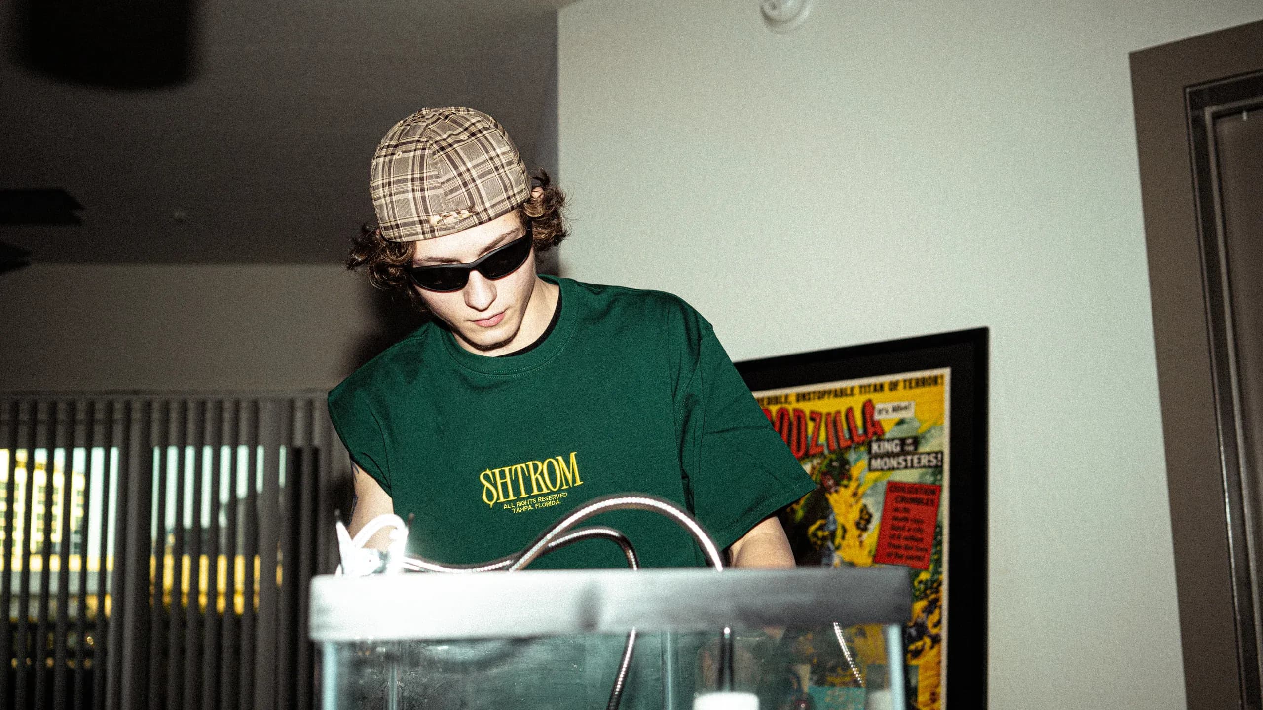 A SHTROM team member in a branded tee, setting up a product shot.