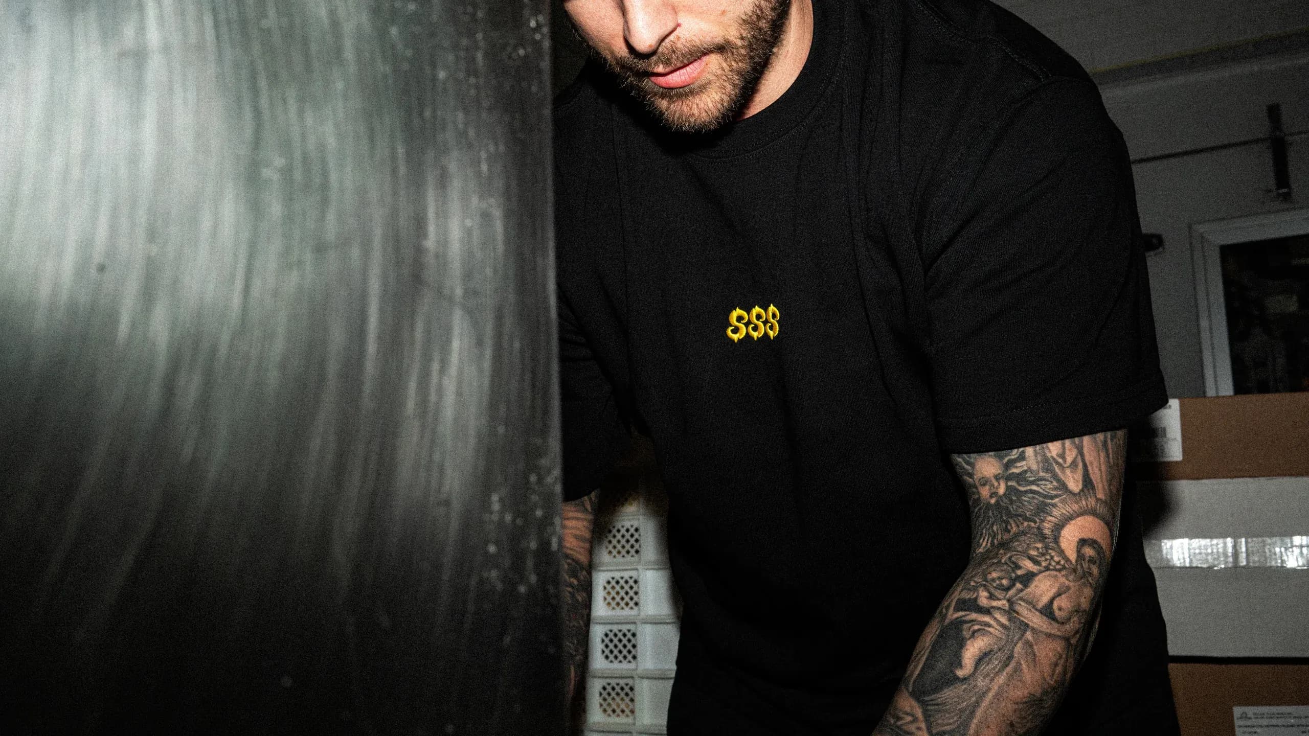 A SHTROM team member caught mid-shoot, tattoos visible.