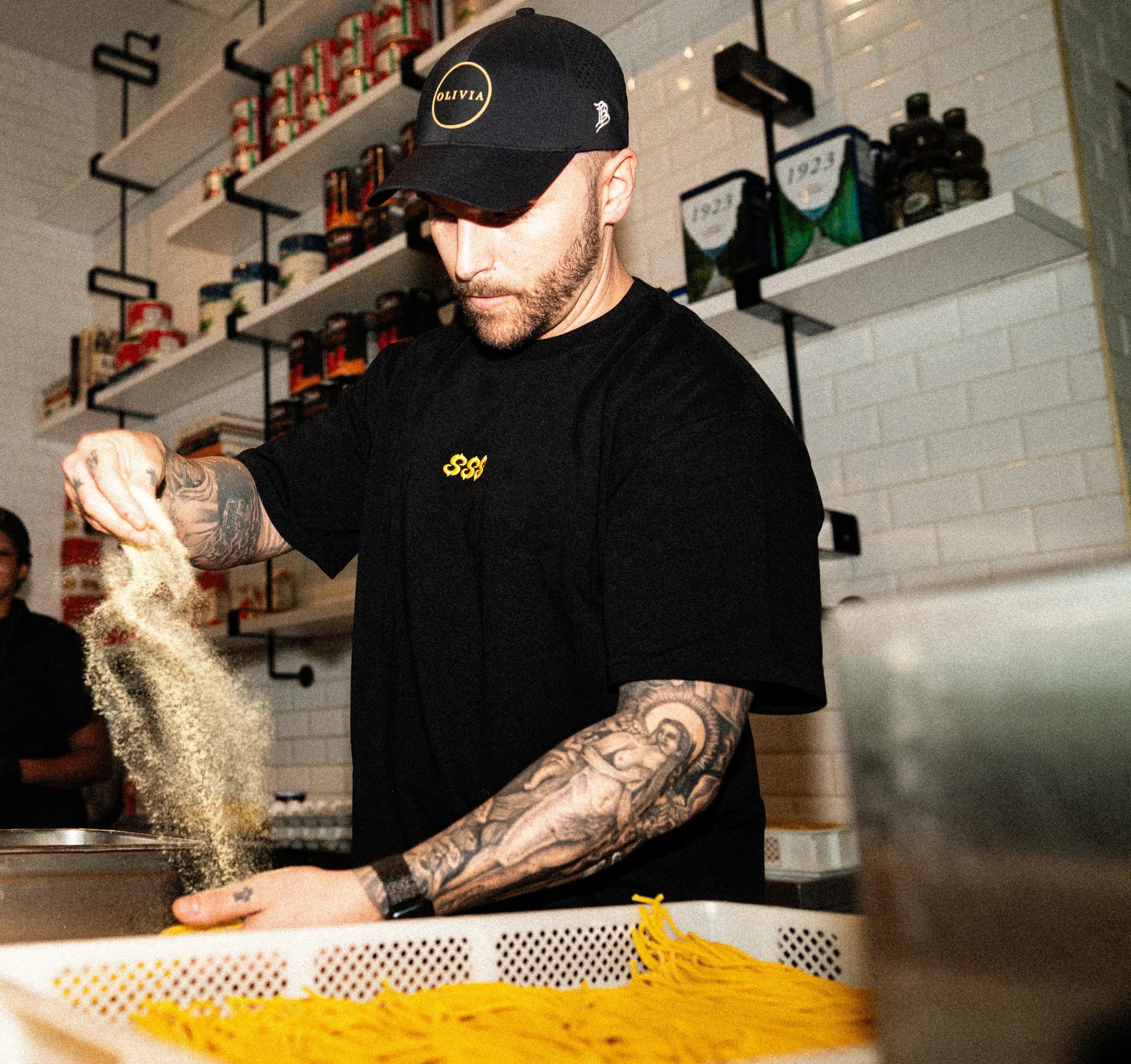 A SHTROM team member dusting fresh house-made pasta with flour during a client shoot at Olivia.