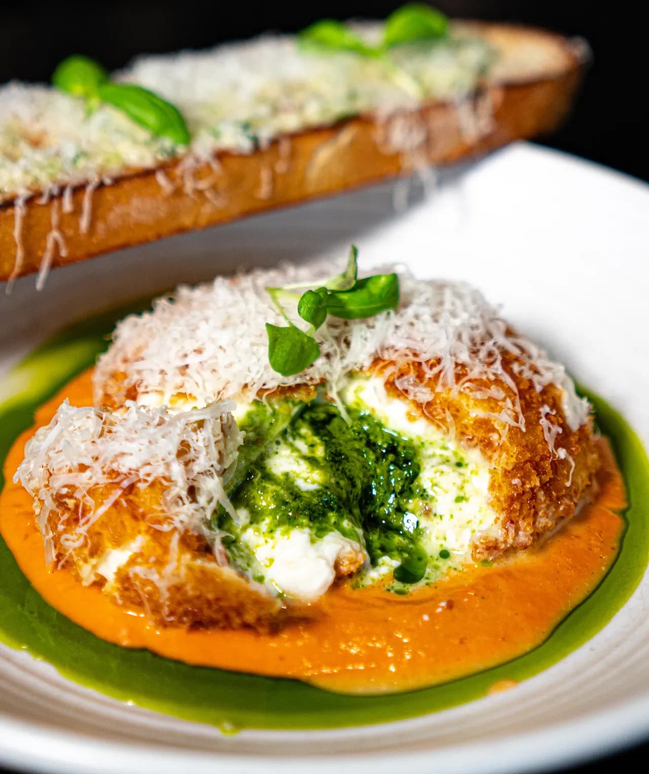 Close-up of Olivia’s burrata, pesto at its centre, over tomato sauce