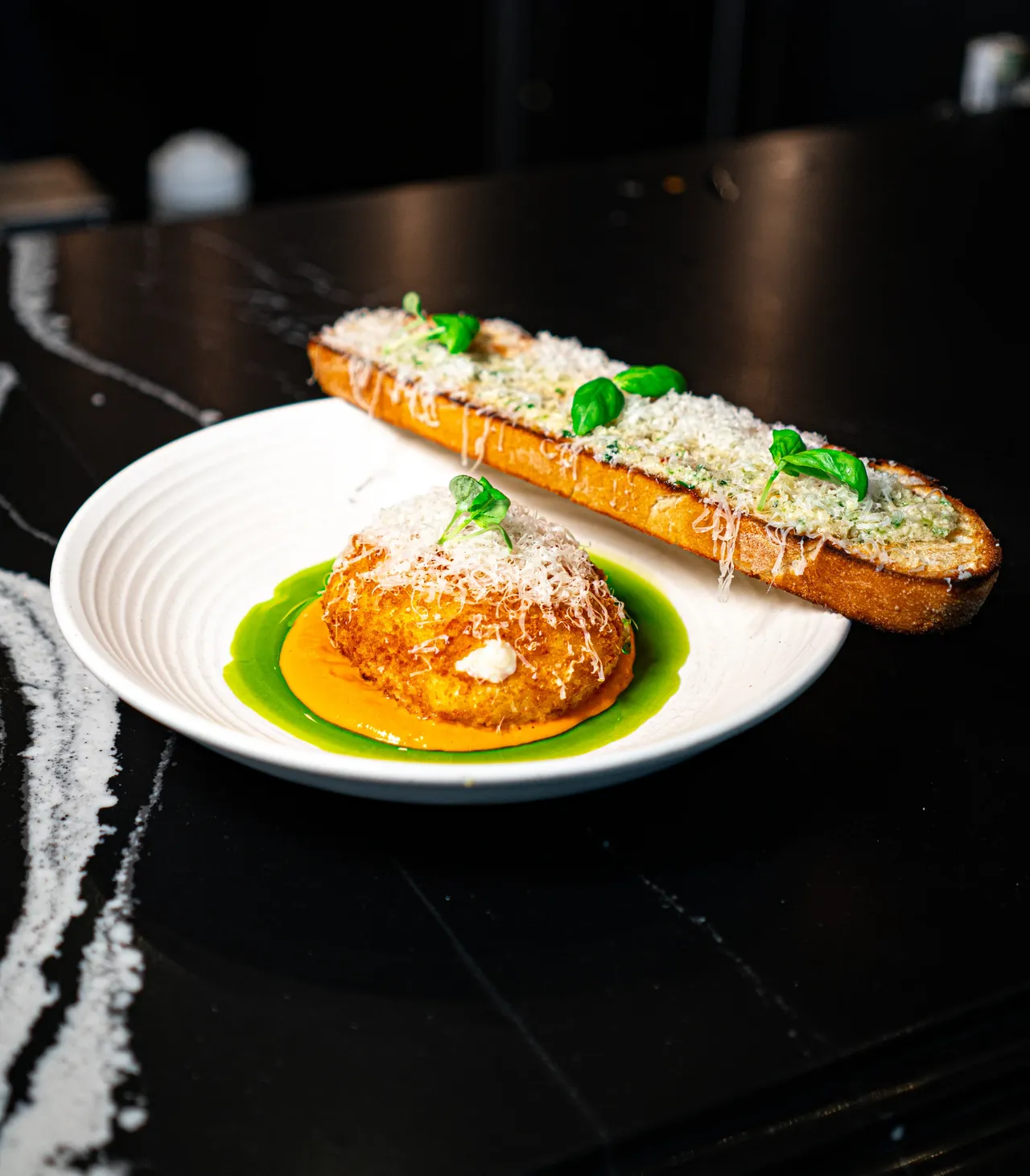 Burrata over tomato sauce with a slice of grilled cheese bread at Olivia