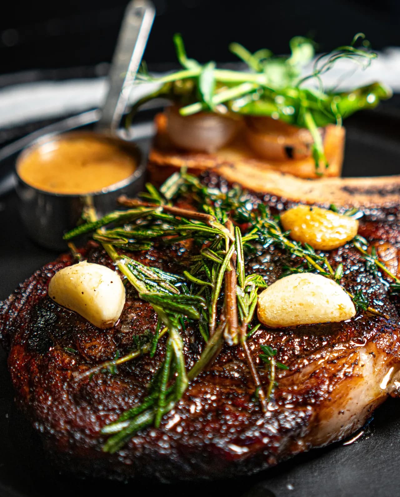 Bone-in steak with roasted garlic, shallots and fresh herbs at Olivia