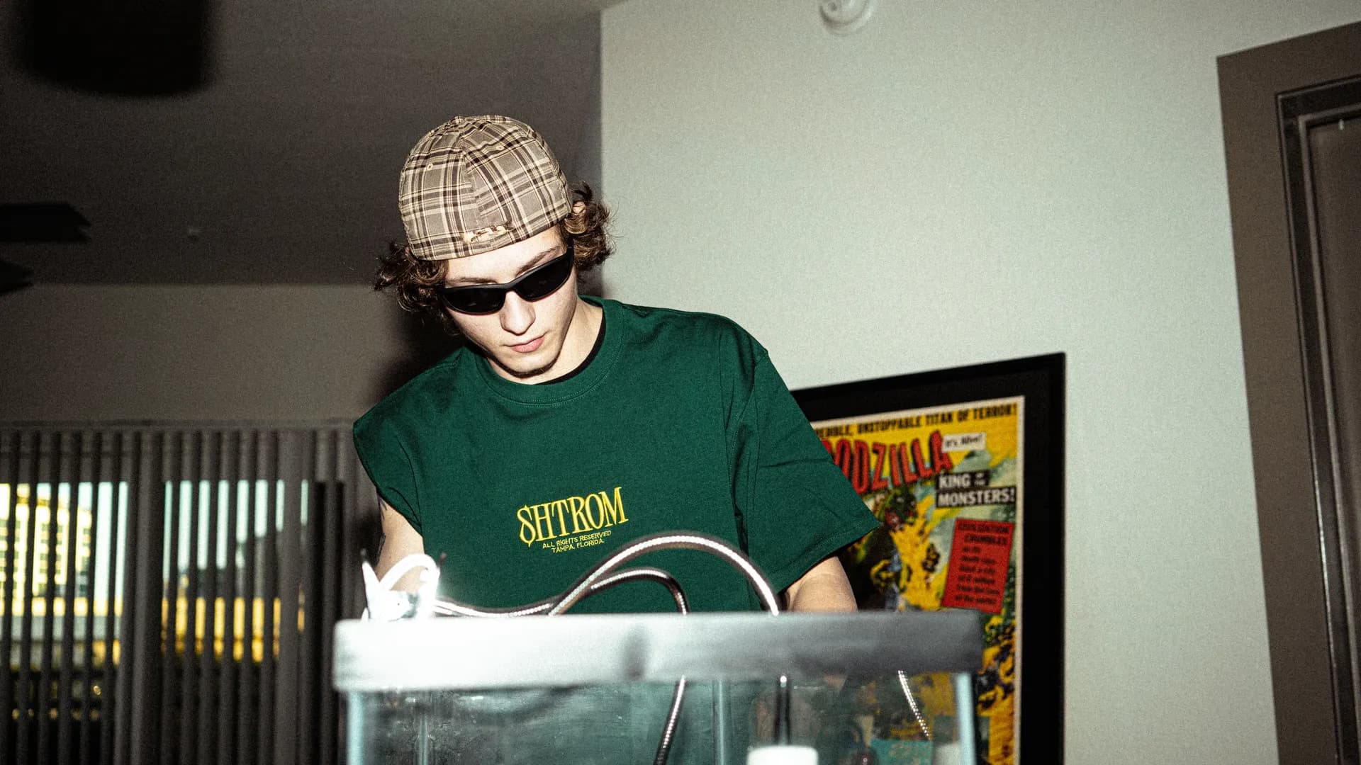 A SHTROM team member in a branded tee, setting up a product shot.