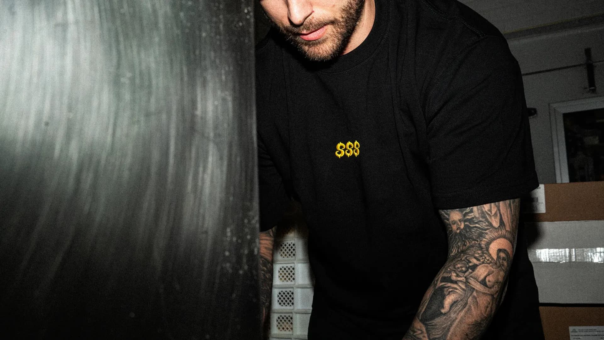 A SHTROM team member caught mid-shoot, tattoos visible.