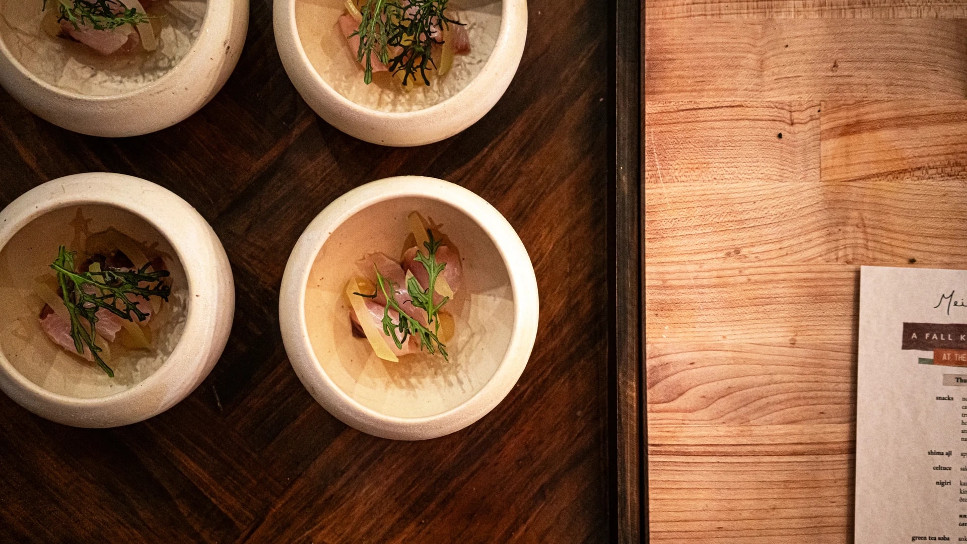 Overhead: kaiseki courses in hand-thrown ceramic bowls on the wooden counter at Mei, St. Petersburg
