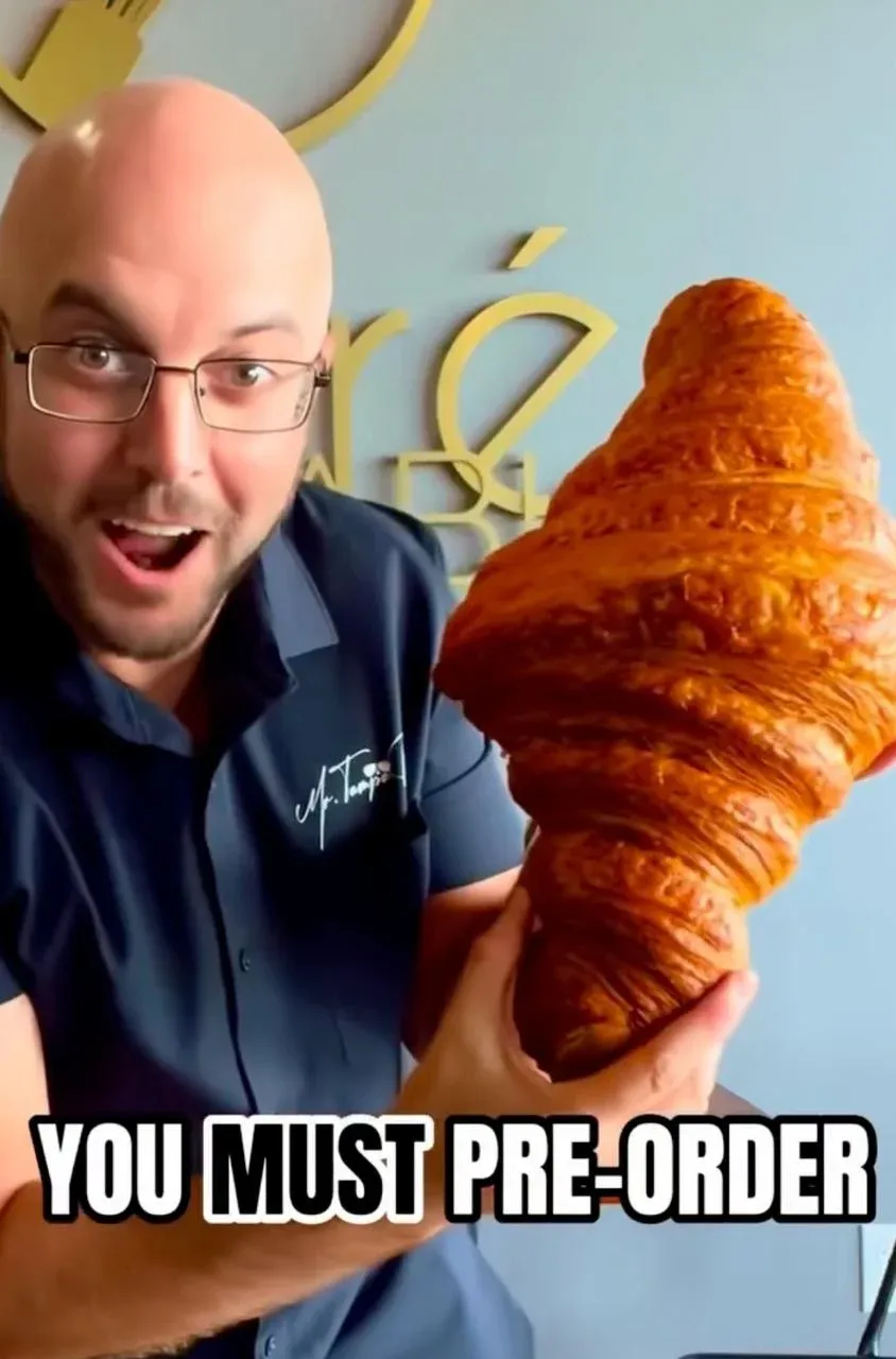 Joe Malinowski, Mr. Tampa Bay, holding up an oversized croissant