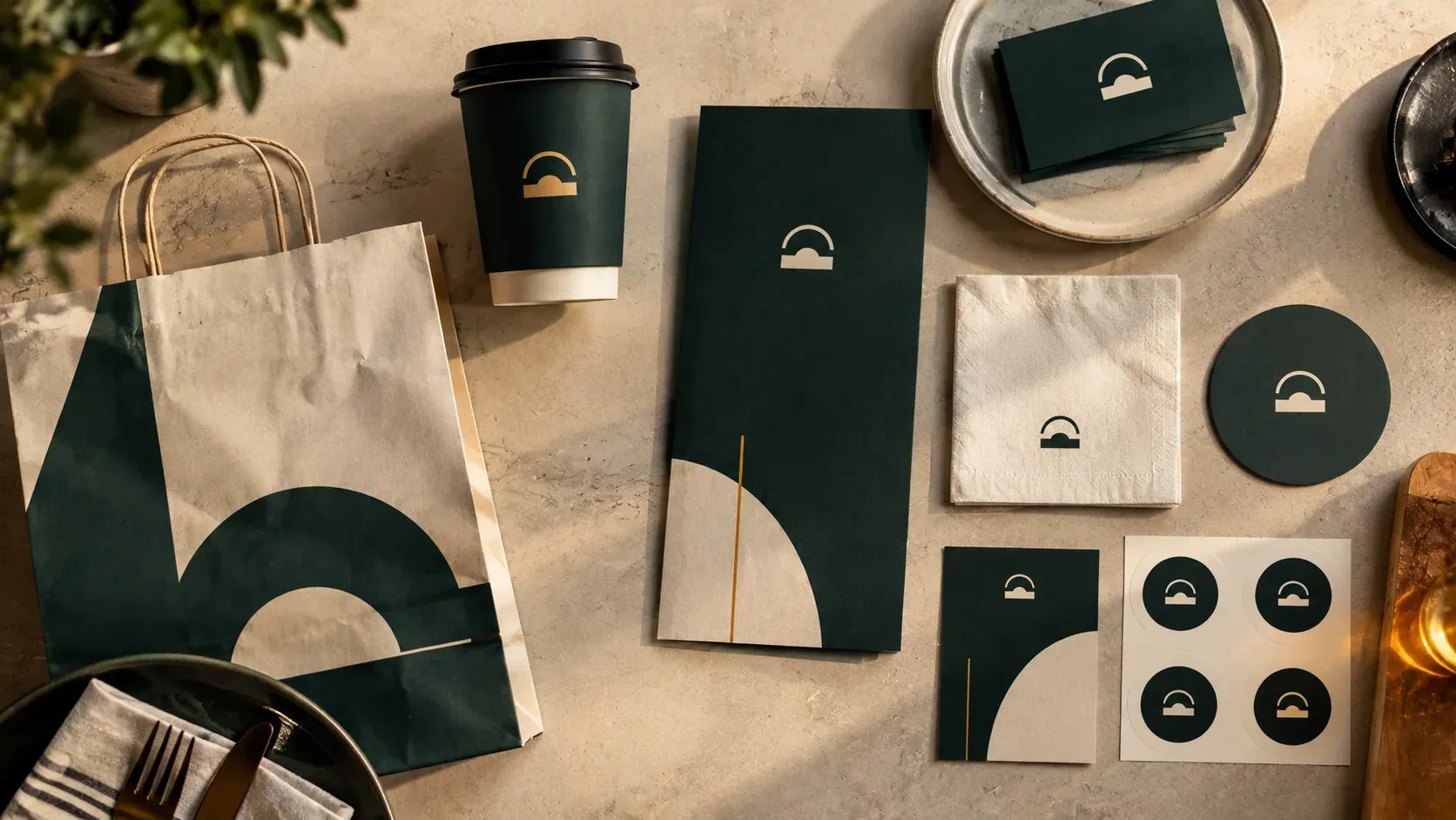 A restaurant's cup, menu, bag, napkin, coaster and cards laid out together, all sharing one consistent brand identity.