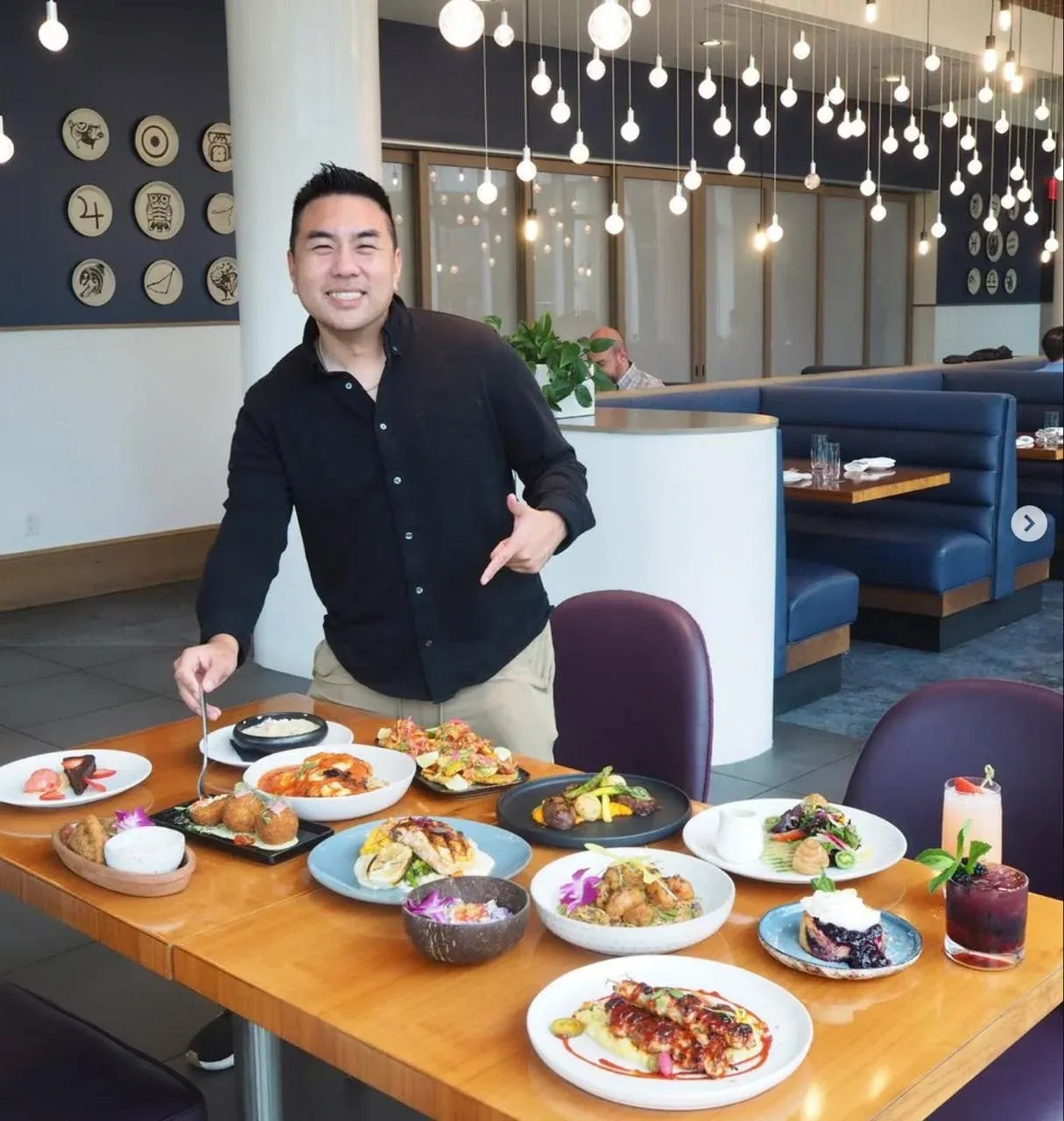 Ricky Ly of Tasty Chomps presenting a table of dishes in an Orlando restaurant